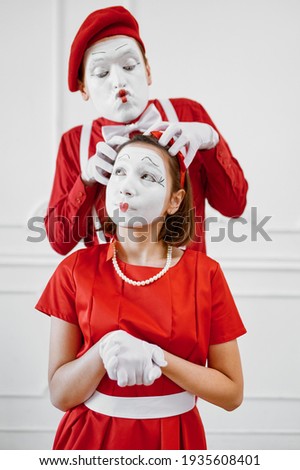 Two mime artists with face and hand makeup