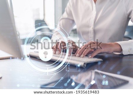 A woman programmer is typing a code on computer to protect a cyber security from hacker attacks and save clients confidential data. Padlock Hologram icons over the typing hands. Formal wear. Royalty-Free Stock Photo #1935619483
