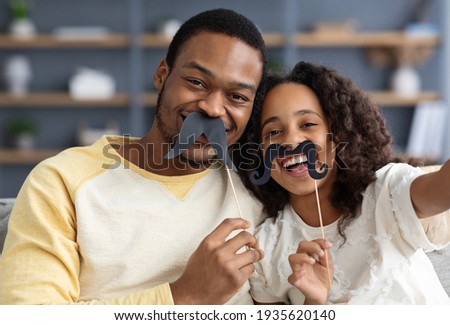 African american father and his little daughter taking funny selfie