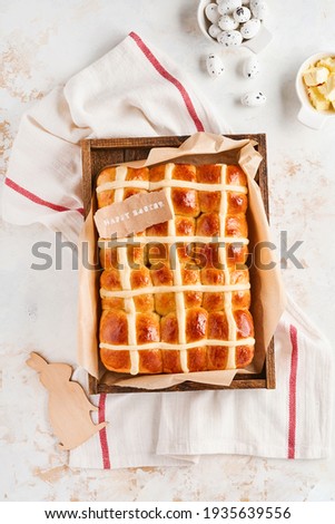 Easter Hot Cross Buns. Traditional breakfast and Easter baking holiday decorations rabbiton white wooden background. Bright colors, view from above on wooden table.