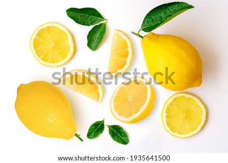 Fresh organic yellow lemon fruit with slice and green leaves isolated on white background . Top view. Flat lay. Royalty-Free Stock Photo #1935641500