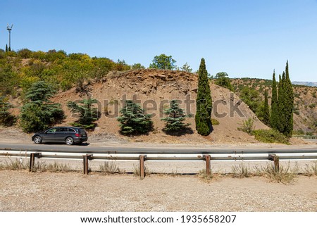 Asphalt Crimean roads in the mountainous area with sharp turns and warning signs, on a summer sunny day.