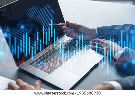 Two business people working together on stock market strategy. Try to analyze forex behavior. Financial graph hologram. Double exposure. Royalty-Free Stock Photo #1935688930