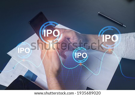 Man using phone. Hands typing smartphone. Double exposure with ipo hologram. Close up. Financial graph and analysis concept. Investment. Royalty-Free Stock Photo #1935689020