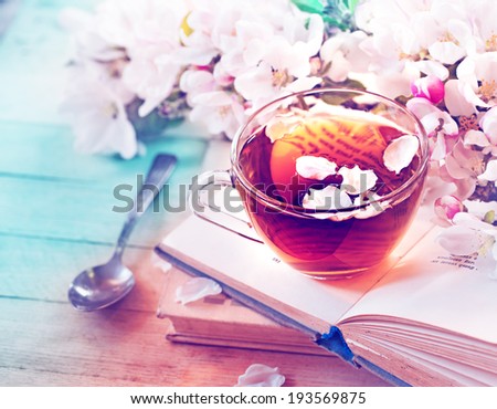 Books, flowers and cup of tea on wooden table Royalty-Free Stock Photo #193569875