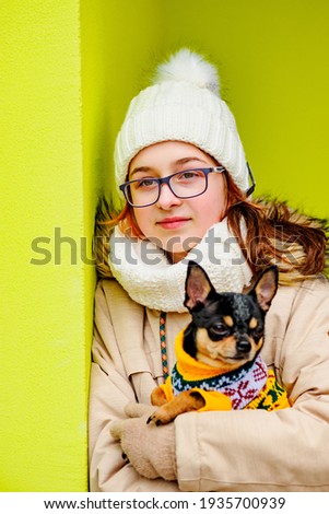 Pretty girl with chihuahua. Teenage girl and chihuahua on the street. Girl with glasses with a dog.