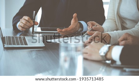 Business people discussing contract working together at meeting in modern office. Unknown businessman and woman with colleagues or lawyers at negotiation Royalty-Free Stock Photo #1935713485