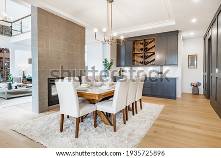 Elegant and large staged dining room with dark cabinets and walls. Royalty-Free Stock Photo #1935725896