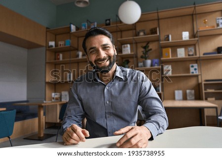 Happy indian business man, teacher talking to web cam on conference video call. Smiling businessman coach laughing, looking camera during webinar, online class, virtual meeting. webcam view screenshot Royalty-Free Stock Photo #1935738955
