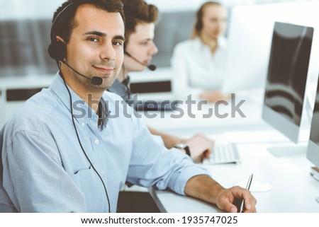 Call center. Group of casual dressed operators at work. Adult businessman in headset at customer service office. Telesales in business Royalty-Free Stock Photo #1935747025