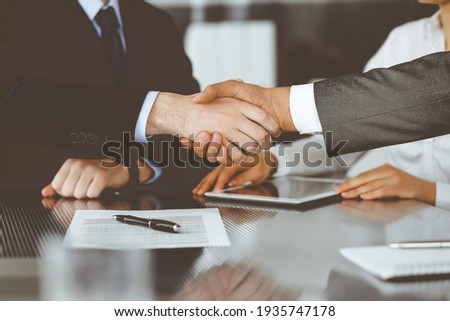 Handshake as successful negotiation ending, close-up. Unknown business people shaking hands after contract signing in modern office Royalty-Free Stock Photo #1935747178