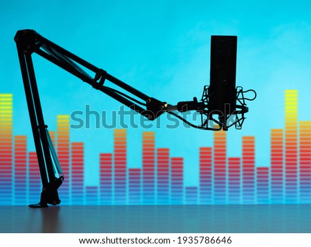 Microphone as a symbol of broadcasting. Silhouette of a microphone on an equalizer background. Device of radio presenter on a tripod. Working device for a radio host. Microphones for radio broadcasts