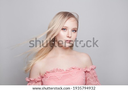 Stylish young woman with blonde hairstyle on white background