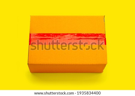 Cardboard box on yellow background.