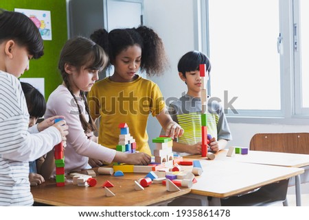 group of Diversity of school students playing wooden blocks in classroom. Elementary school children enjoy learning together. Learn to work as a team. Back to school concept Royalty-Free Stock Photo #1935861478