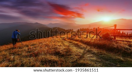Amazing nature scenery. Alone hiker, photographer taking a picture Majestic mountains during sunset. Stunning sunset in the mountains landscape with sunny beams. Carpathian mountains, Ukraine, Europe. Royalty-Free Stock Photo #1935861511