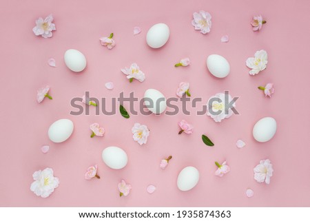 Easter eggs on pink background decorated with sakura flowers. Selective focus. Spring pattern