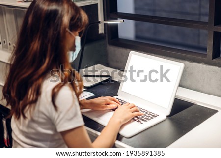 Woman relaxing using technology of laptop computer with white mockup blank screens on the table at home.Communication and technology concept
