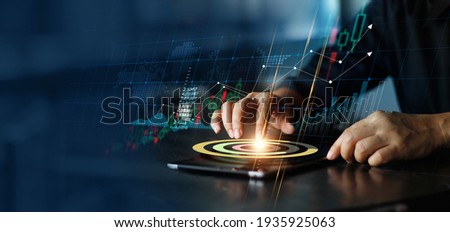 Businessman touching pie chart on tablet and analyzing sales data and economic growth graph chart. Financial. Stock market and banking on dark background. Royalty-Free Stock Photo #1935925063