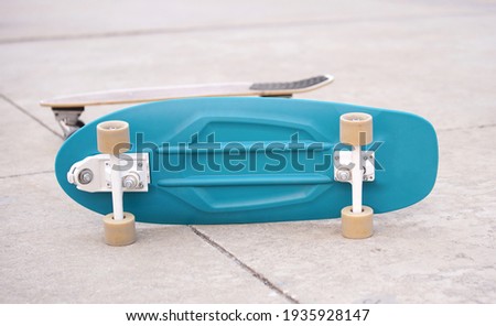 Surf Skate, extreme sport with four wheels on board sliding on street or pump track. Famous teenager sport in urban. Blue board lays on ground with yellow wheels Royalty-Free Stock Photo #1935928147