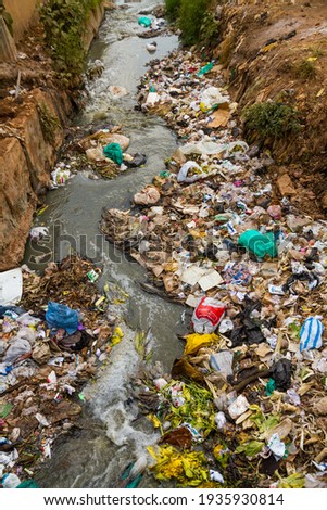 A heavily polluted river filled with all kinds of garbage, trash, and sewage in the Kibera slum of Nairobi, Kenya. Royalty-Free Stock Photo #1935930814