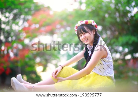 Teenage asian girl sitting on floor in a park