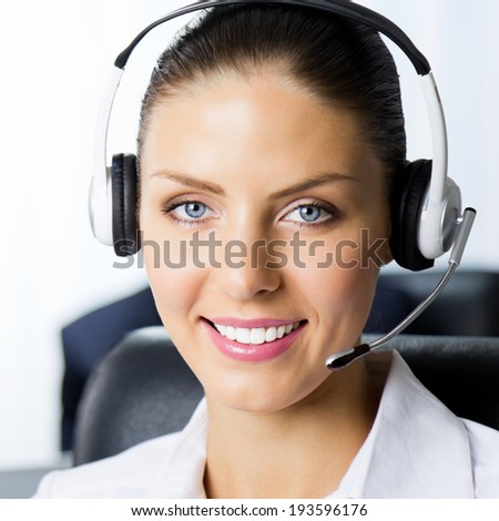 Portrait of happy smiling female support phone operator at workplace