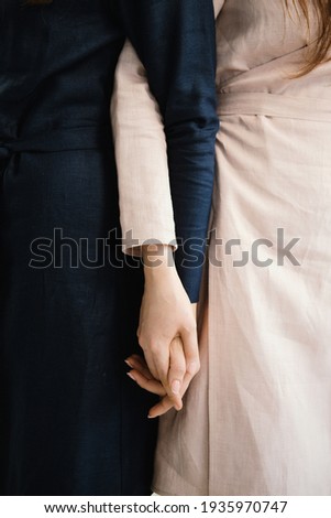 Two sisters hold hands. symbol of friendship, support and unity.