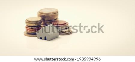 HOusing boom Affordable Accommodation Decide mortgage loan, investment, real estate and property concept - house model and stack coins 