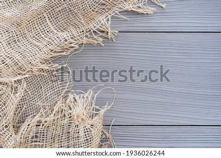 Decorative rough hemp fabric on a wooden table as a background for use in other works and photographs.