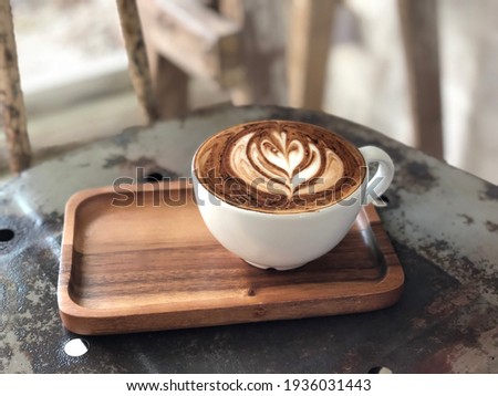 ็Hot cappuccino cup on wooden table background Royalty-Free Stock Photo #1936031443