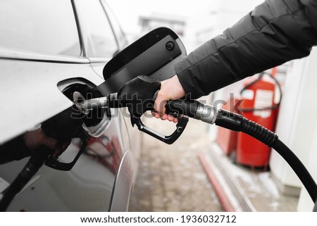 Male hand close-up refueling a black car. higher oil prices Royalty-Free Stock Photo #1936032712