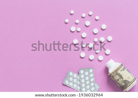 Medical bottle with dollars and packagings with pills. The concept of insurance medicine, high cost of drugs. Isolated on a pink background.