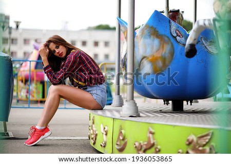 Cute girl in a clown makeup on a background of a fair and steps
