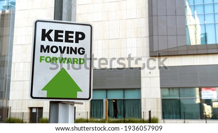 Keep Moving Forward sign in a downtown city setting