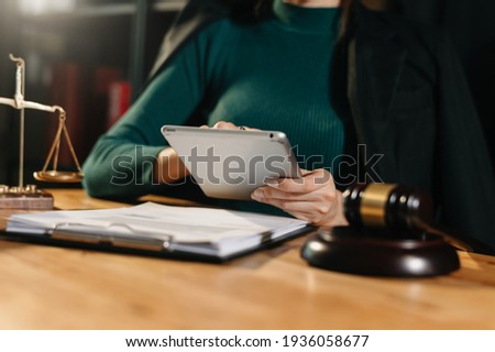 justice and law concept.Male judge in a courtroom  the gavel, working with smart phone and laptop and digital tablet computer on wood table in morning light 
