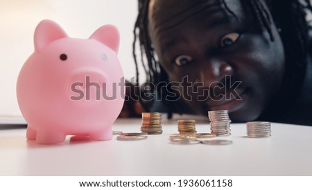 Man counting his savings. Close up of piggybank surrounded by coins. Investing decision. High quality photo