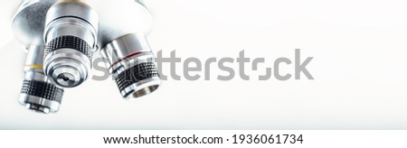 Detail of microscope lens on an isolated white background. Royalty-Free Stock Photo #1936061734