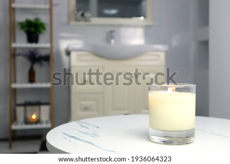 aromatic scented candle glass is put on the white marble table in a luxury white bathroom toilet to creat relax and cozy and clean ambient
 Royalty-Free Stock Photo #1936064323