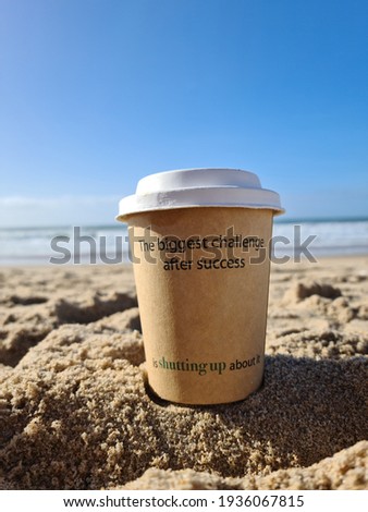 Inspirational motivation quote - The biggest challenge after success is shutting up about it. Place for next. With text on an paper coffee cup on ocean and clear sky background.  Love yourself concept