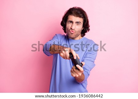 Photo of interested curly hairdo guy hold playstation wear purple sweater isolated on pastel pink color background