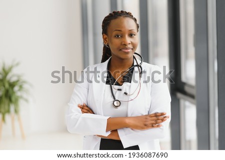 beautiful african american nurse with arms folded Royalty-Free Stock Photo #1936087690