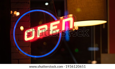 Neon glowing sign open on the window of restaurant in the night evening dark time