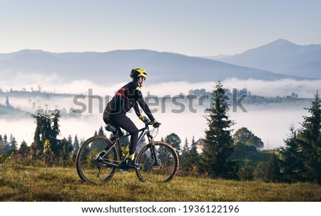 Male cyclist riding bicycle in mountains. Royalty-Free Stock Photo #1936122196