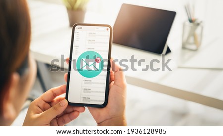 Woman hand holding smartphone and show email screen on application mobile in the office. Royalty-Free Stock Photo #1936128985