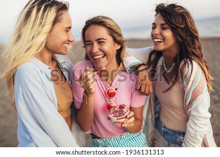 Girls eating ice cream on the beach, selective focus