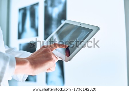 doctor is using a digital tablet to communicate with the patient.