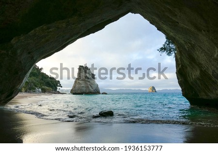 Te Hoho Rock seen through a rock arch at a coastal area named Cathedral Cove in the southern part of Mercury Bay on the Coromandel Peninsula at the North Island of New Zealand Royalty-Free Stock Photo #1936153777