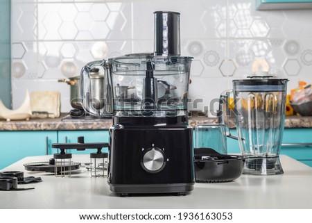 Natural light. black food processor. Near the nozzle for use. In the background is a kitchen for cooking Royalty-Free Stock Photo #1936163053