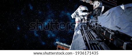 Astronaut spaceman do spacewalk while working for space station in outer space . Astronaut wear full spacesuit for space operation . Elements of this image furnished by NASA space astronaut photos. Royalty-Free Stock Photo #1936171435
